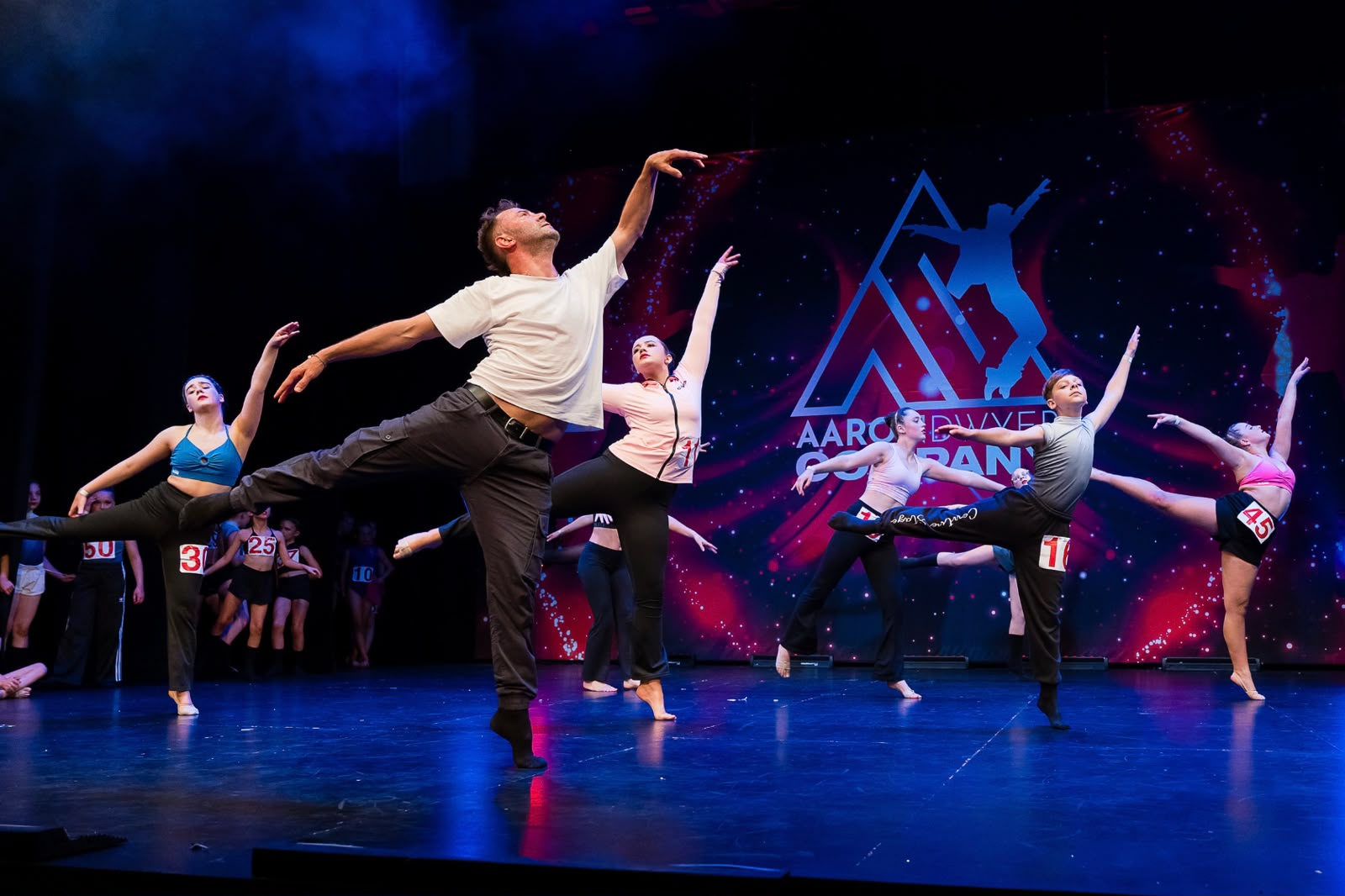 Aaron Dwyer leading dancers through an audition workshop on stage.